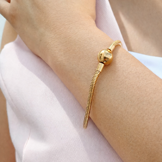 Pulsera tipo pandora de acero con broche esfera dorada